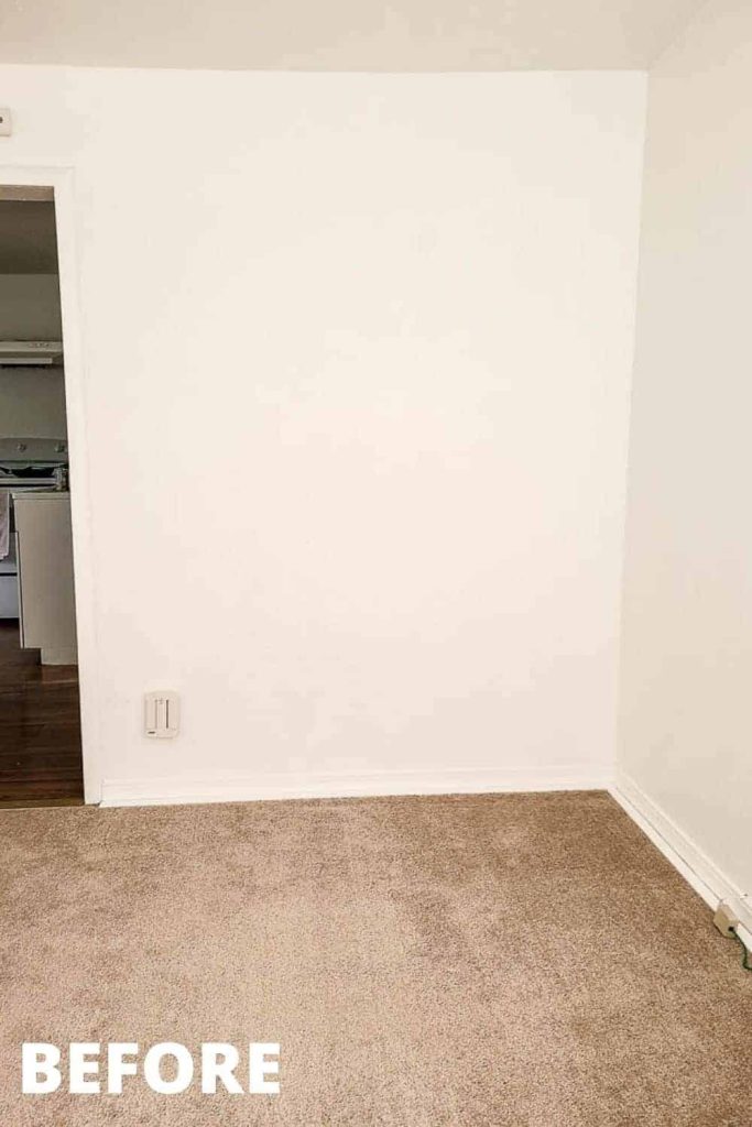 shows a empty white corner in a studio apartment with before in the corner of the picture