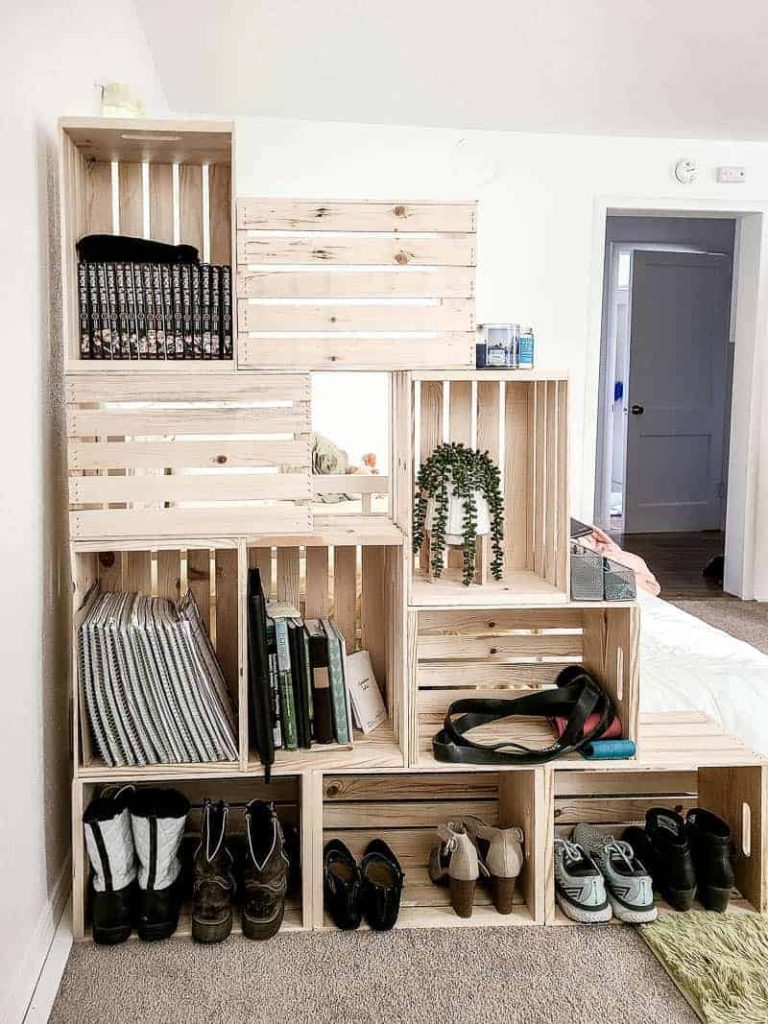 shows the 10 wood crates filled with shoes, books and plants in a white room