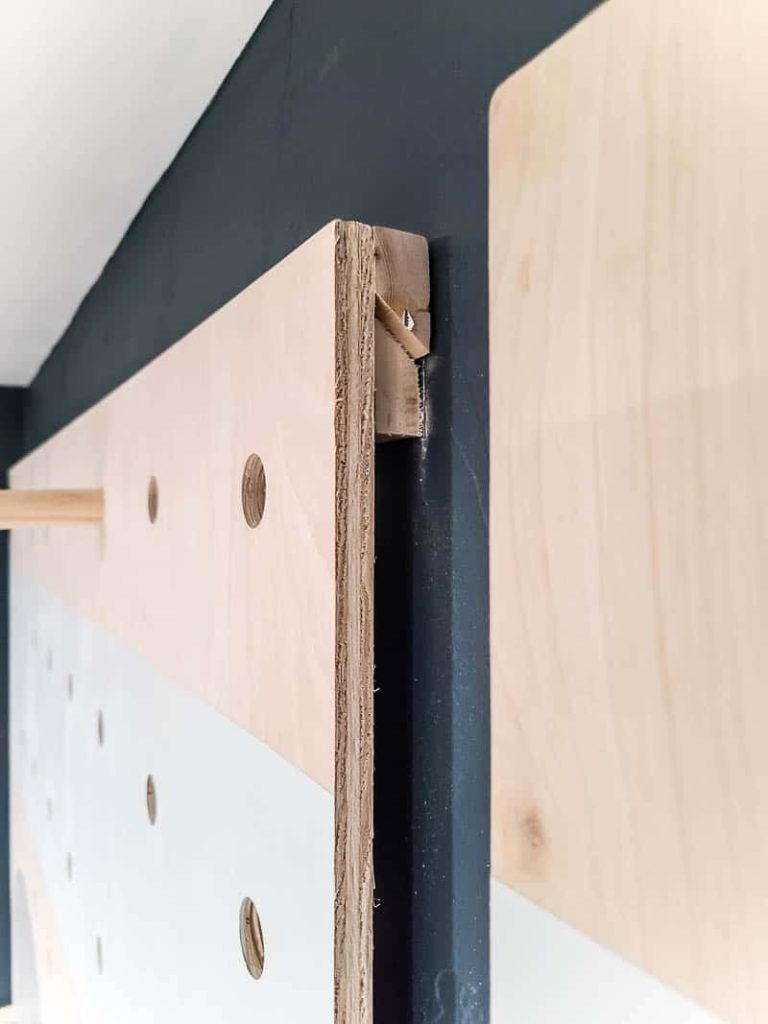 A closeup look at the pair of french cleats holding up the installed pegboard wall in our home office area.