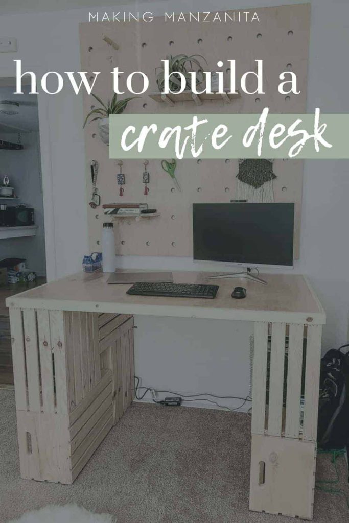 shows a face on view of the wood crate desk with a computer on it and a wood wall behind it with overlay text that says how to build a crate desk