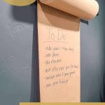 shows a wall mounted paper roll holder with overlay text that says how to make a paper roll holder video tutorial