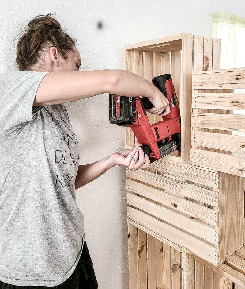 shows a woman nailing together wood crates