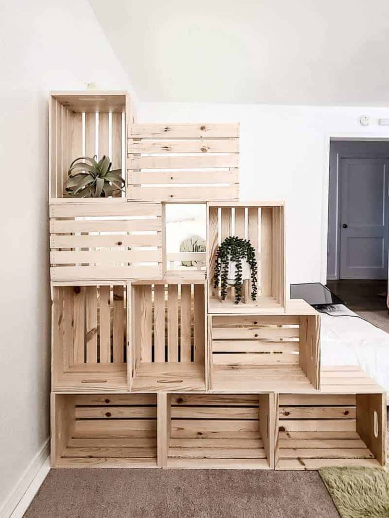 shows 10 wood crate stacked on each other to create a wall with some plants in it