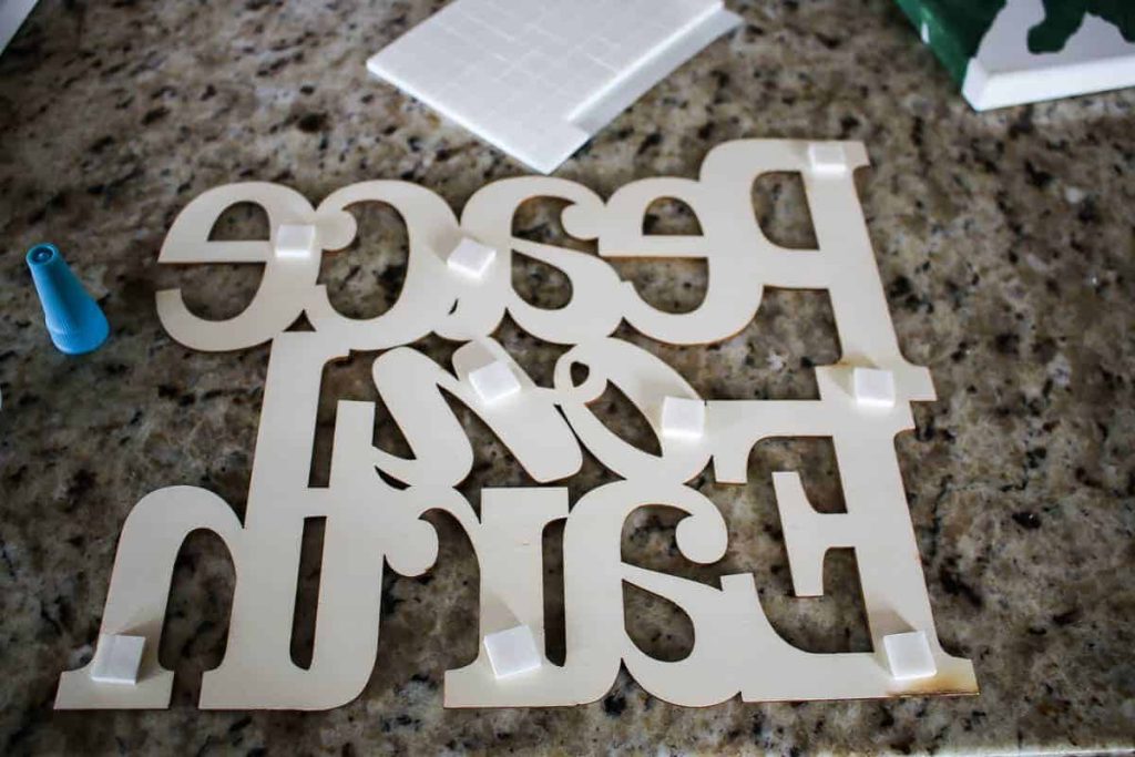 shows glued foam squares on the back of a peace on earth sign