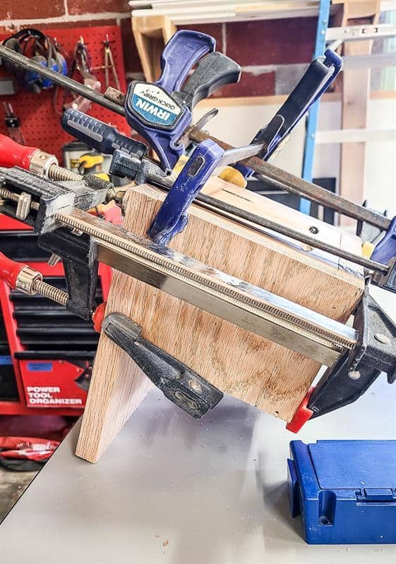 The wood is being assembled with wood glue using a Kreg Jig, ensuring sturdy and precise joins as the person prepares to drill.