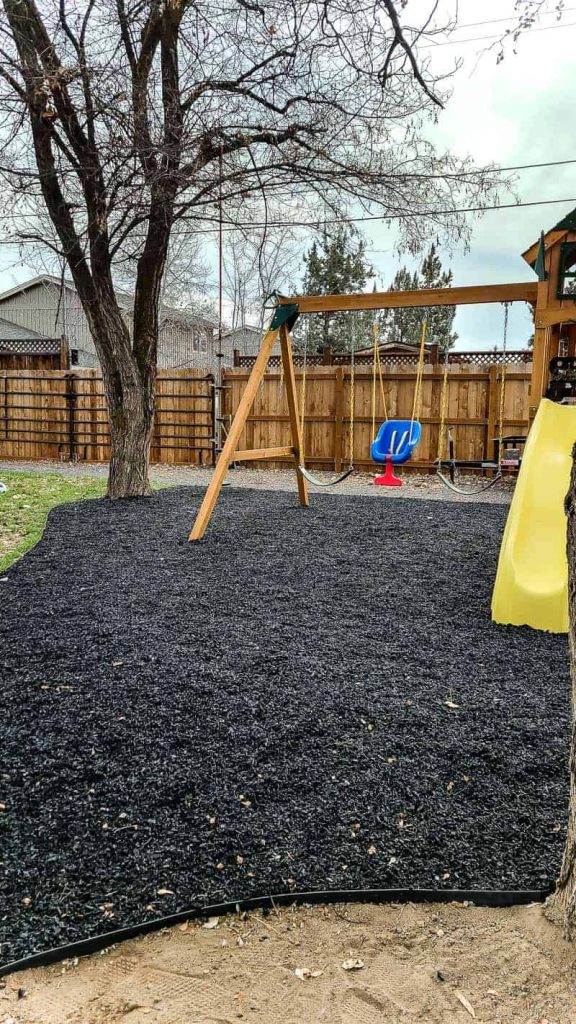 swing set play ground with black ground cover 