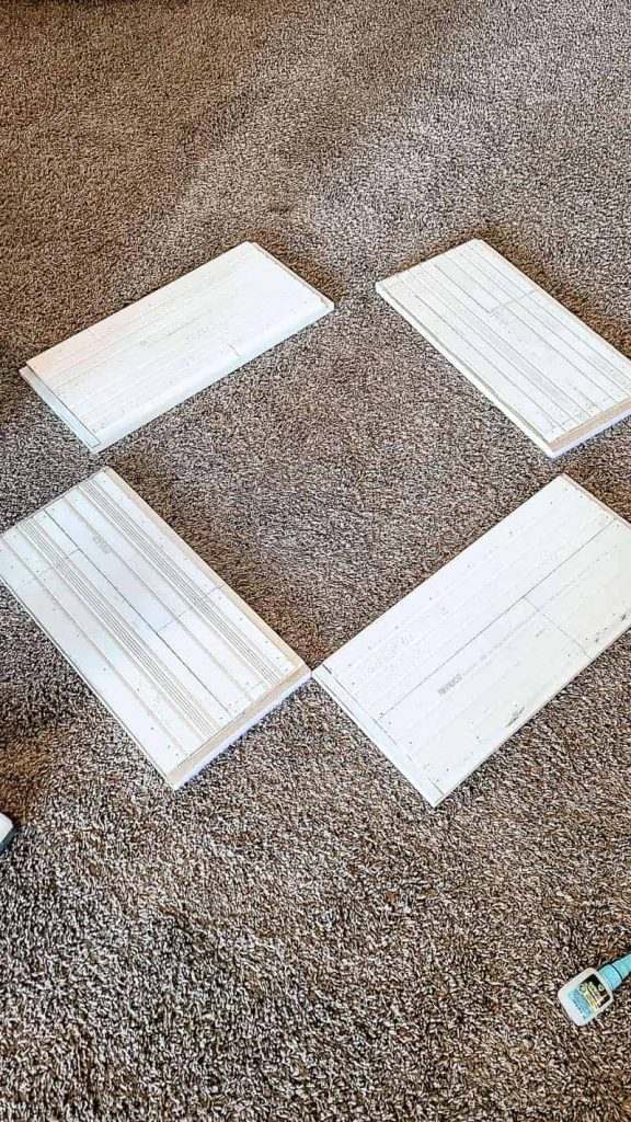 shows the shiplap tree stand pieces laying on the ground to show that they store flat