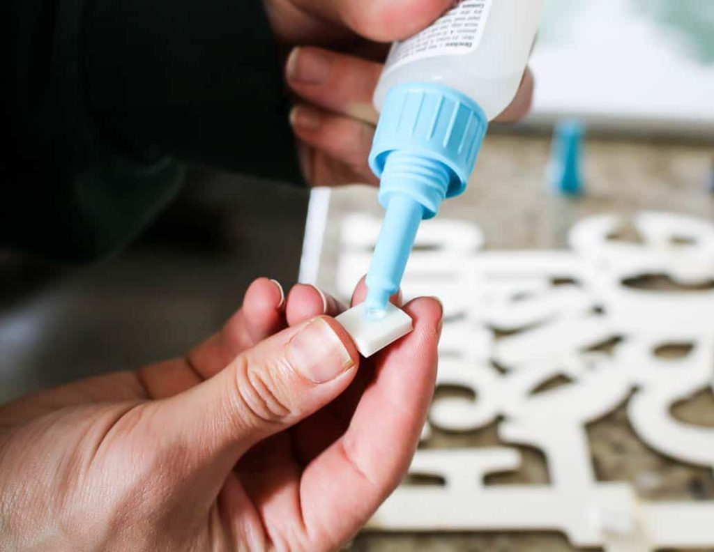 shows a hand gluing on foam squares