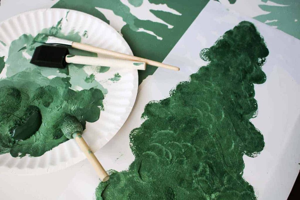 shows the tree painted canvas and a plate of paint and brushes next to it