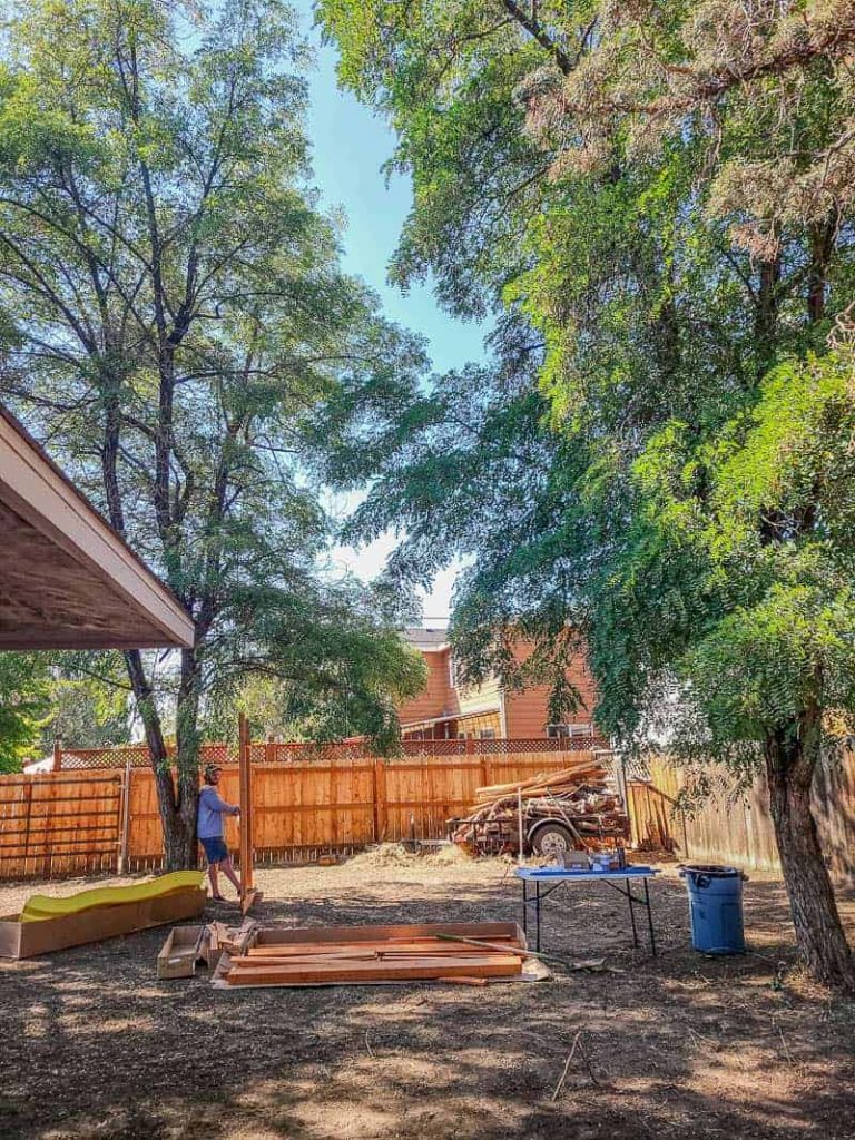 Man setting up new wooden playset in backyard 