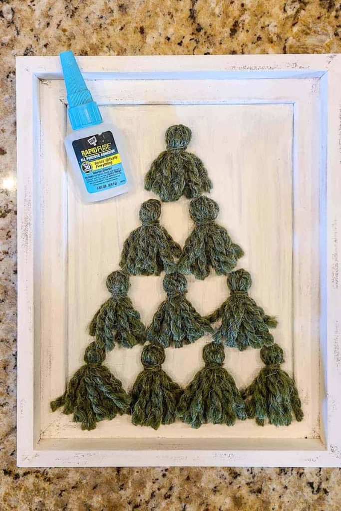 Small green Christmas tree tassels glued to frame with glue