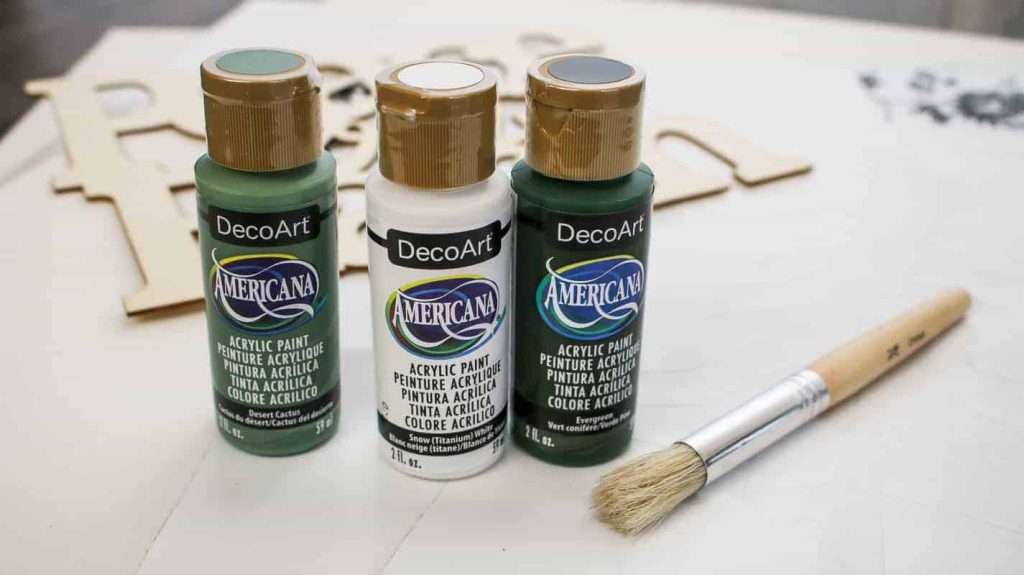 3 different colors of acrylic craft  paint and a paint brush