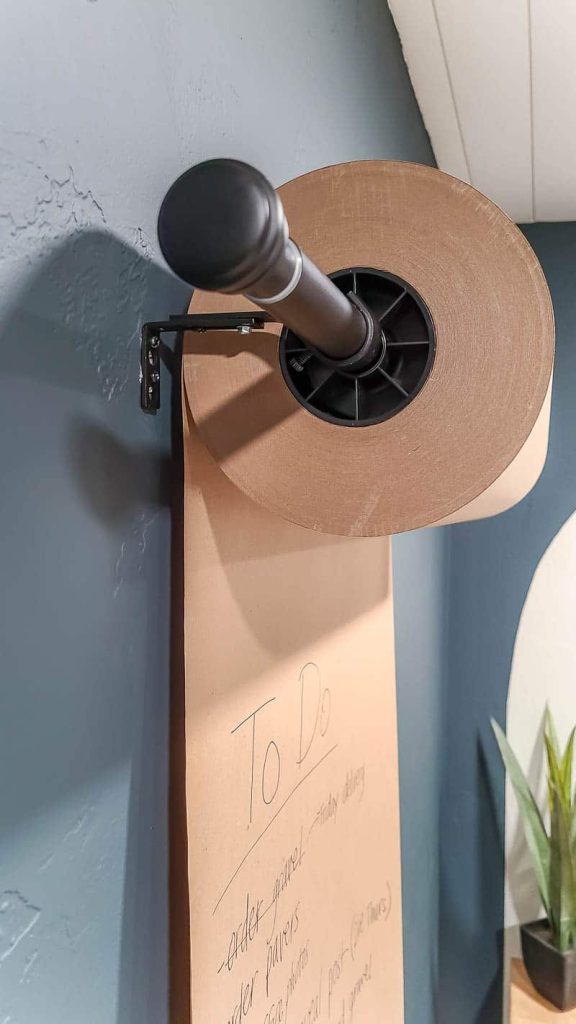 shows the Kraft paper on the dispenser roll hanging on wall in home office with dark green walls