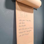 shows the Kraft paper holder mounted on the wall with a to do list on it