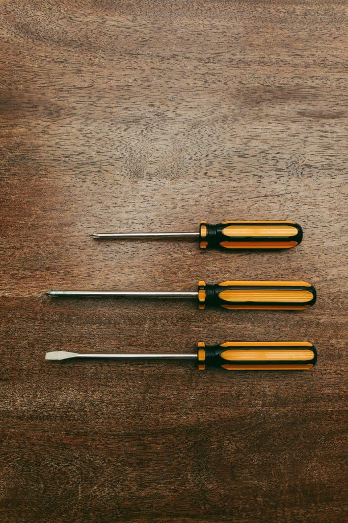 shows 3 different screw drivers laying on wood surface