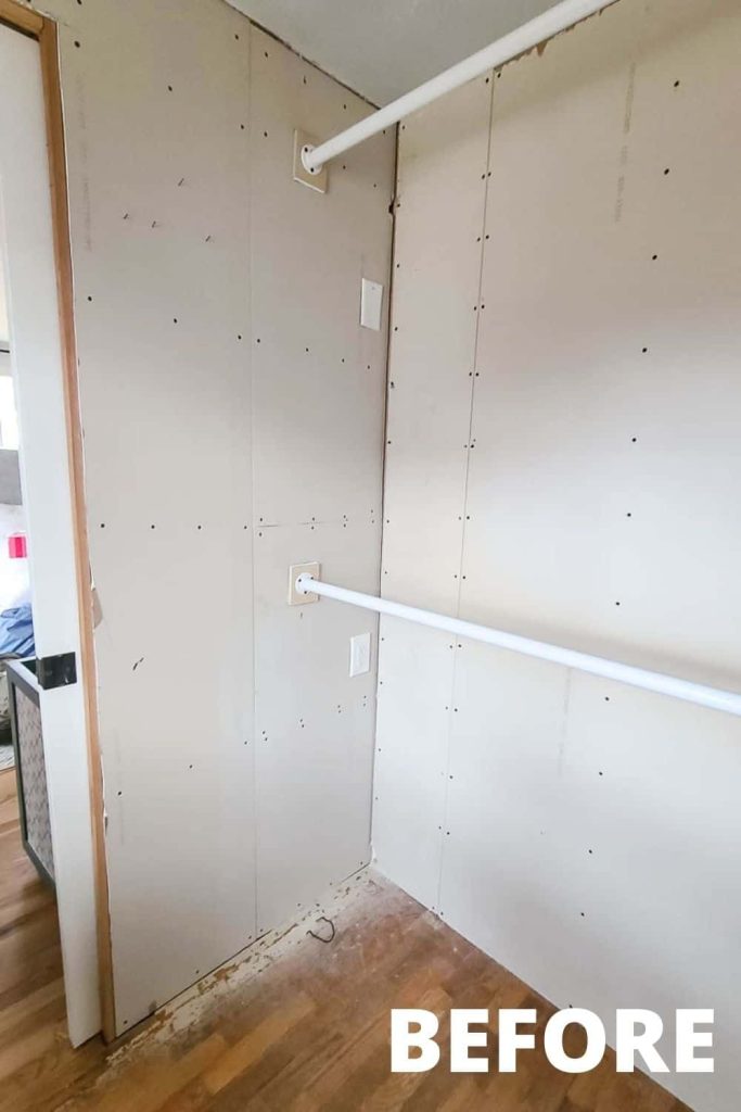 A corner of the empty, unfinished master bedroom closet with two white clothing rods mounted to plain drywall boards.