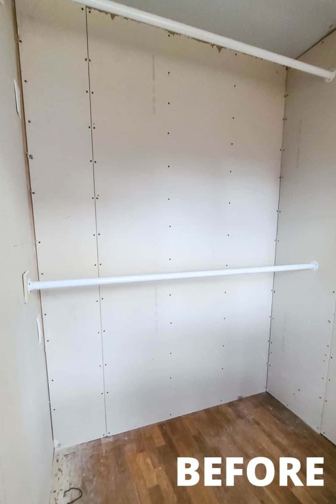 Two empty hanging clothing rods mounted between walls in our unfinished walk-in master bedroom closet.