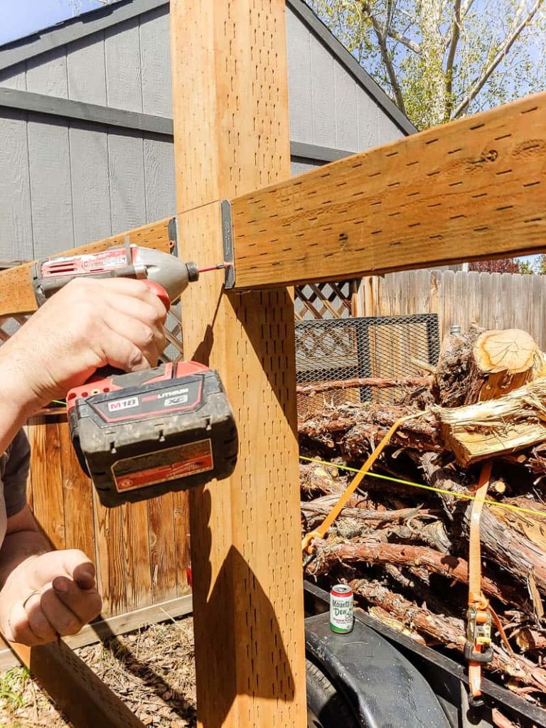 shows someone drilling the bracket for fence rails