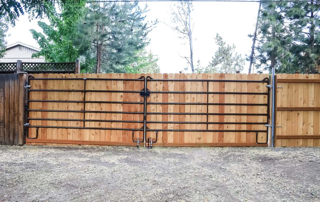 large metal gate in backyard on wood fence