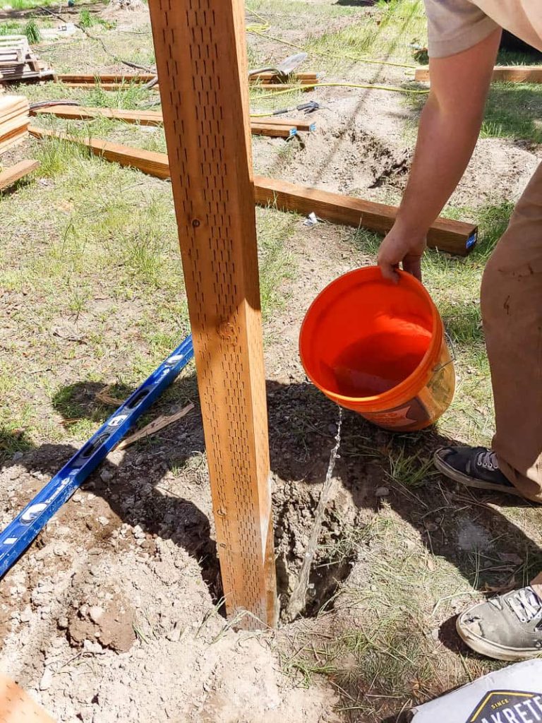 shows a post hole being filled with water and cement