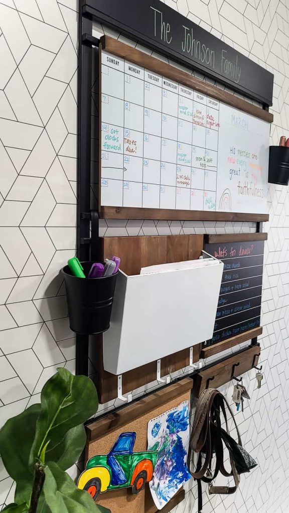 A close up image of the family command center, customized with special elements like a mail holder, whiteboard calendar, hooks, corkboard sign, and a chalkboard memo board.