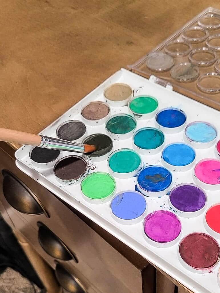 water color paints with hand holding paint brush
