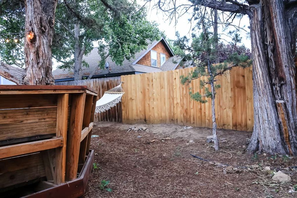 shows a wood fence behind a deck