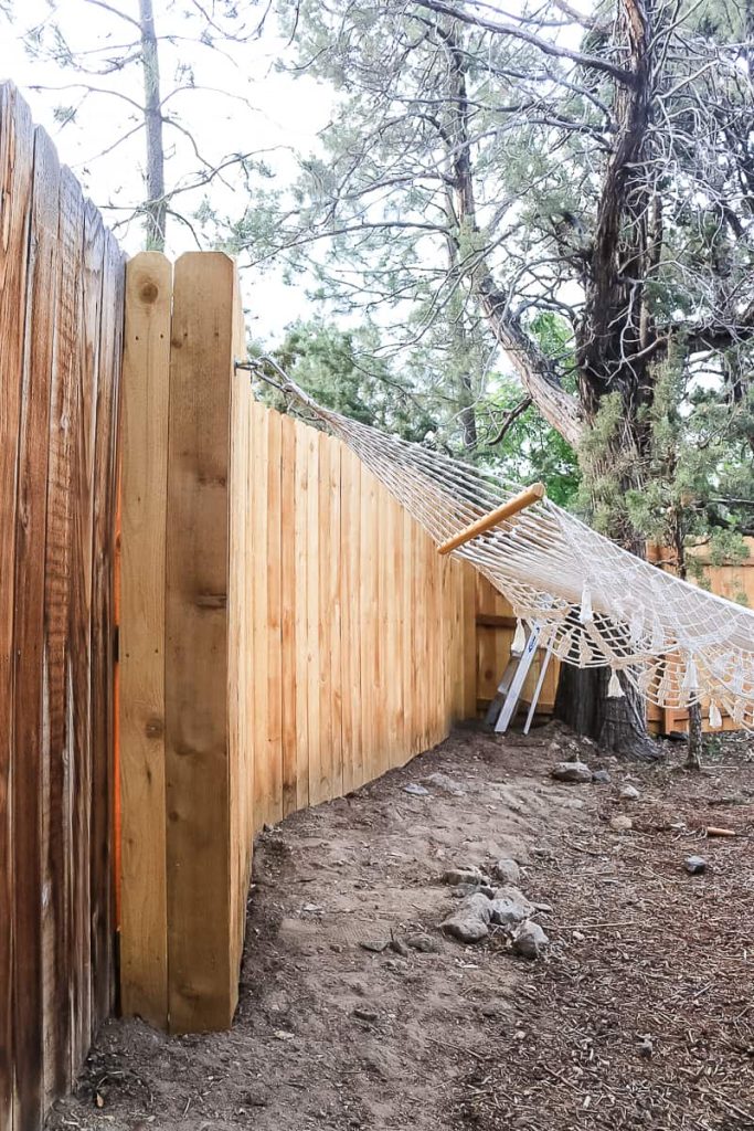wood fence in backyard in macrame hammock