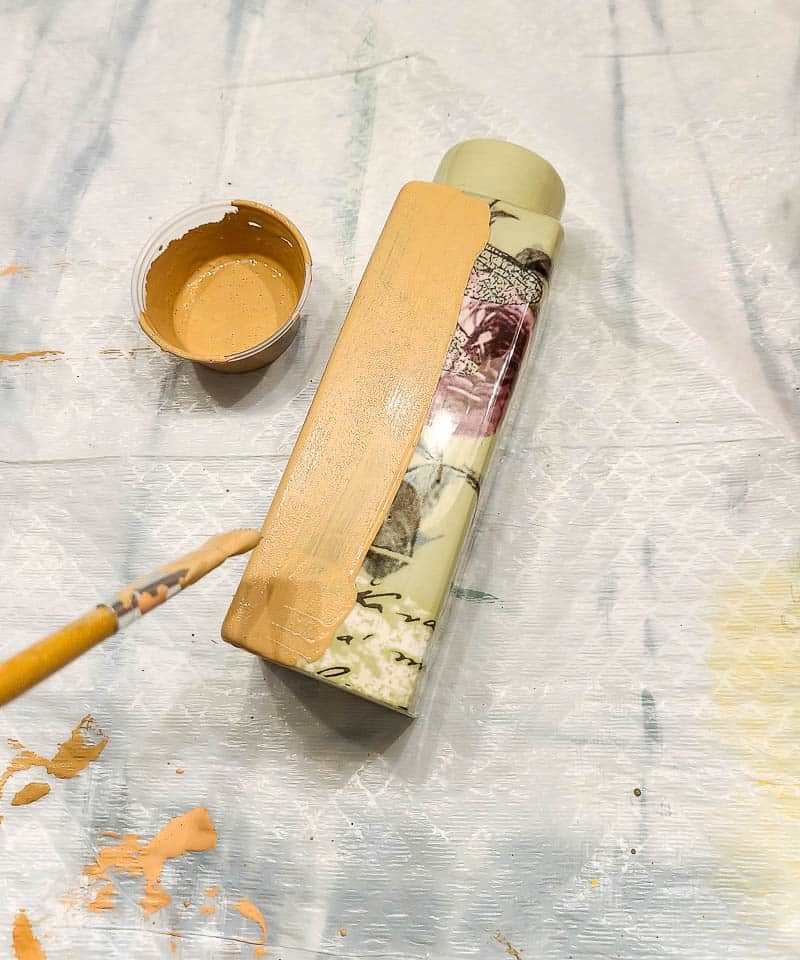 Painting the floral vase with the mixed paint and baking soda in the cup using paint brush