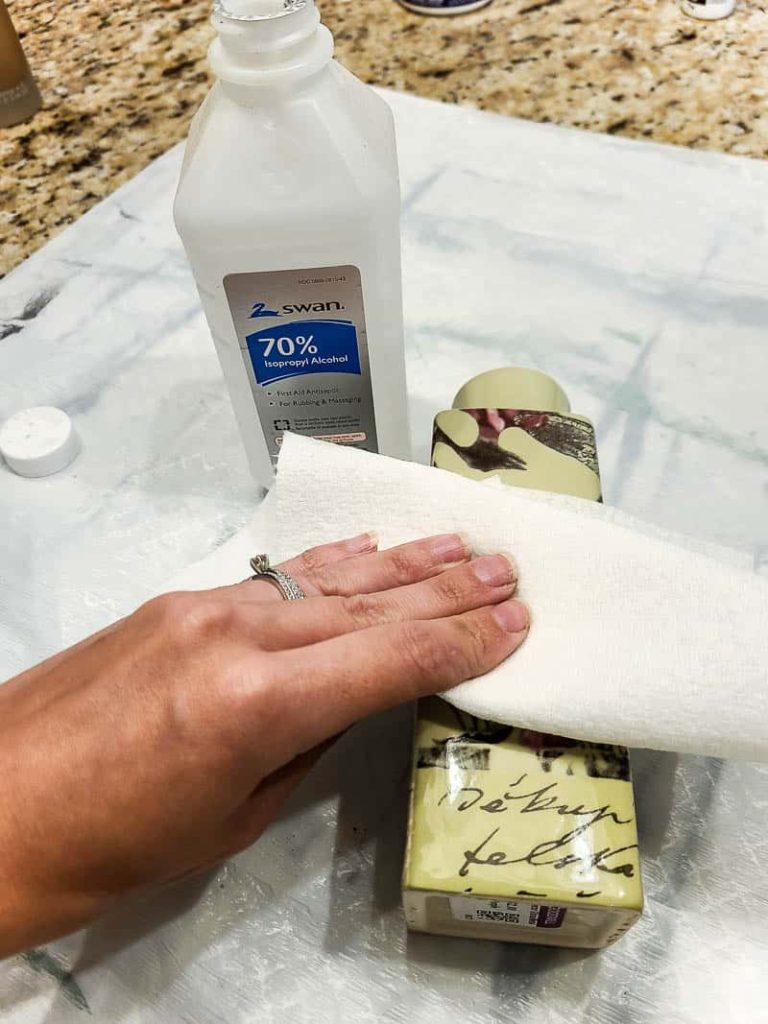 Woman wiping the floral vase with tissue and rubbing alcohol to clean before painting