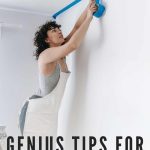 Woman wearing apron standing on a high ladder taping painter's tape on the corner of the ceiling with text overlay that says genius tips for painter's tape