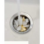 Lemons, ice and salt in sink drain to clean the stinky sink with text overlay that says how to clean your smelly sink