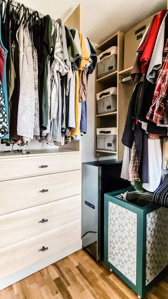 Hanging clothes and storage in the renovated master bedroom walk in closet with new light wood organization system