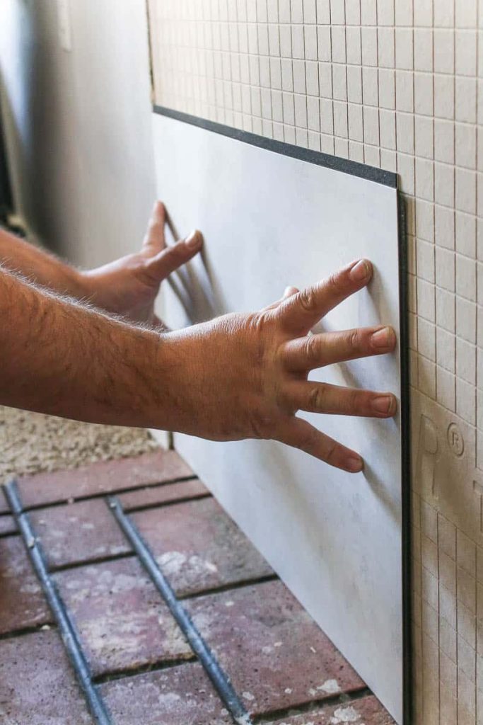 Adhering wall panels to the wall