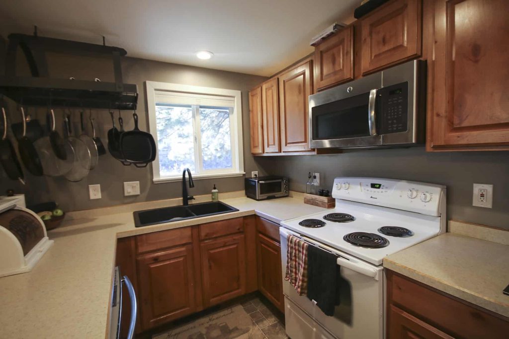 Kitchen full view of Behr Fashion Gray painted walls against Honey oak kitchen cabinets, and tan countertops