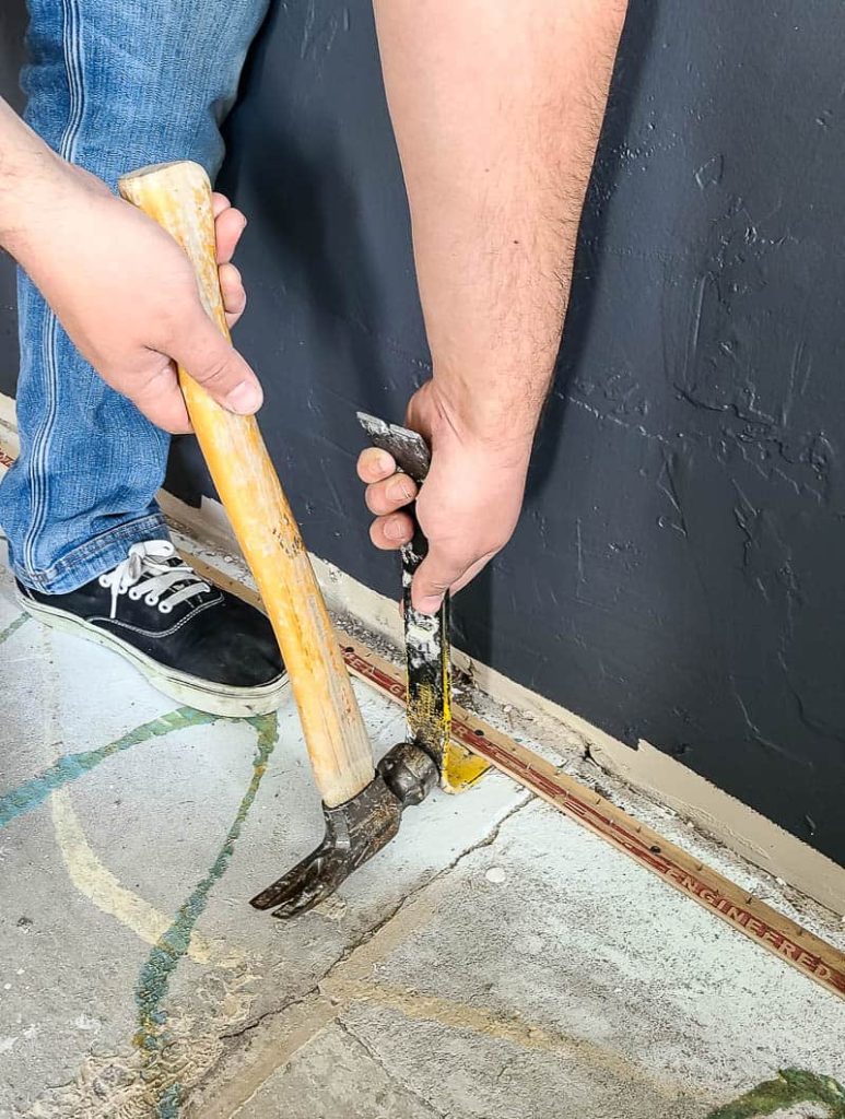  retrait de la bande d'amure du béton avec un marteau et une barre de levier