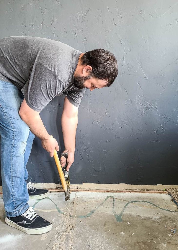 o homem usando martelo e levante a barra para remover orçada tira