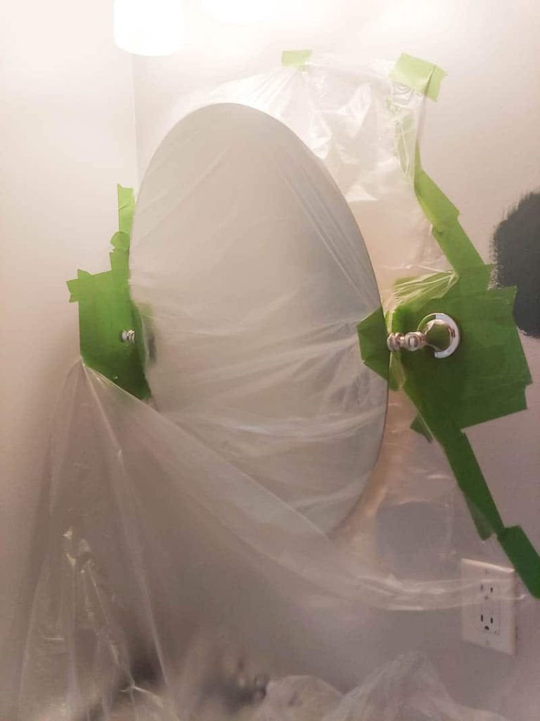 Old mirror covered in plastic and taped off with painter's tape to prepare for spray paint mirror