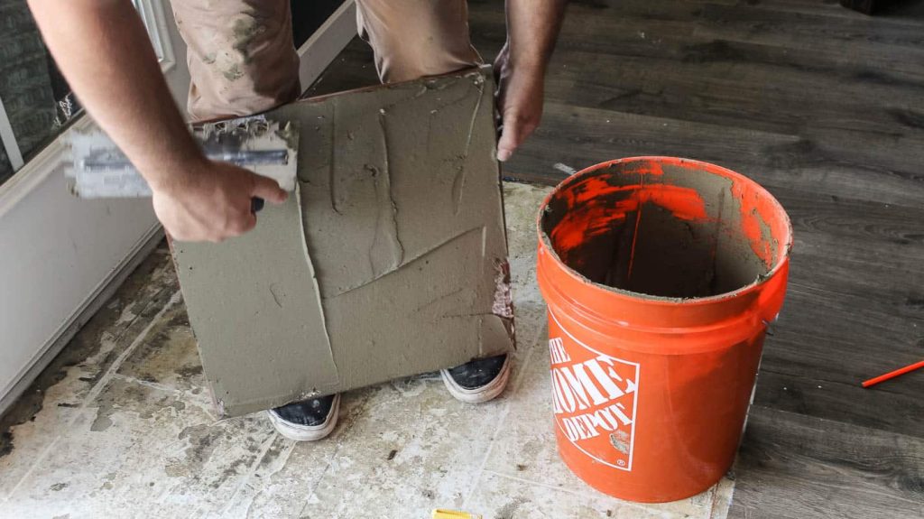 Before you set tiles into place, it is recommended that you back butter large format tiles by adding a thin layer of mortar to the back of the tile