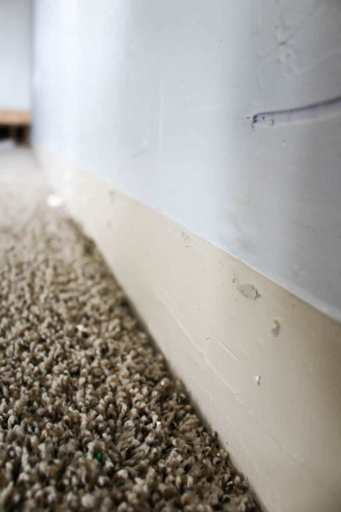bottom of wall and carpet where baseboard use to be in removing baseboards.