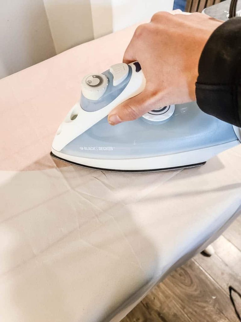 Woman ironing the fabric tapestry using electric iron
