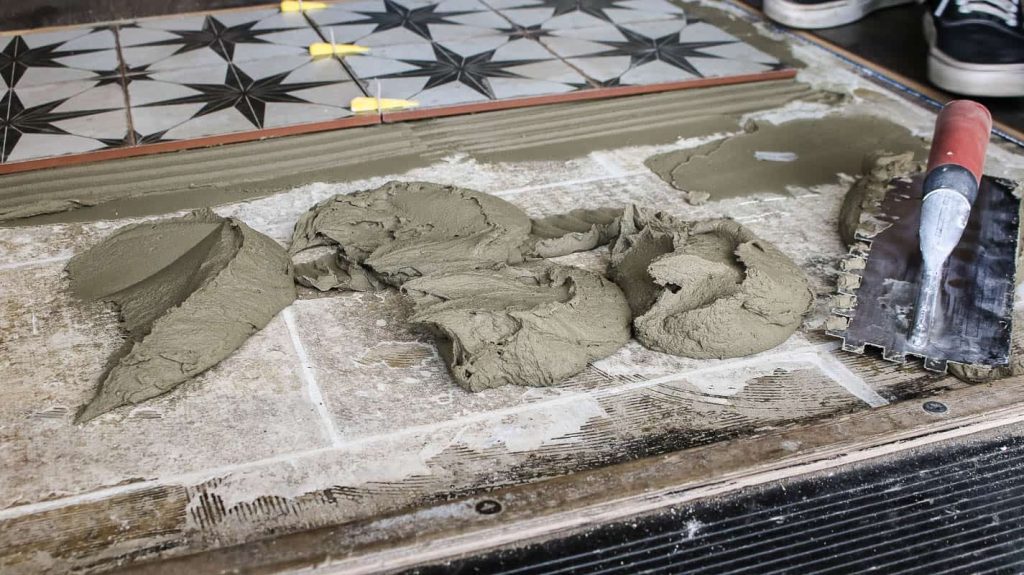 Patches of mortar on the other half of the floor during large format tile installation