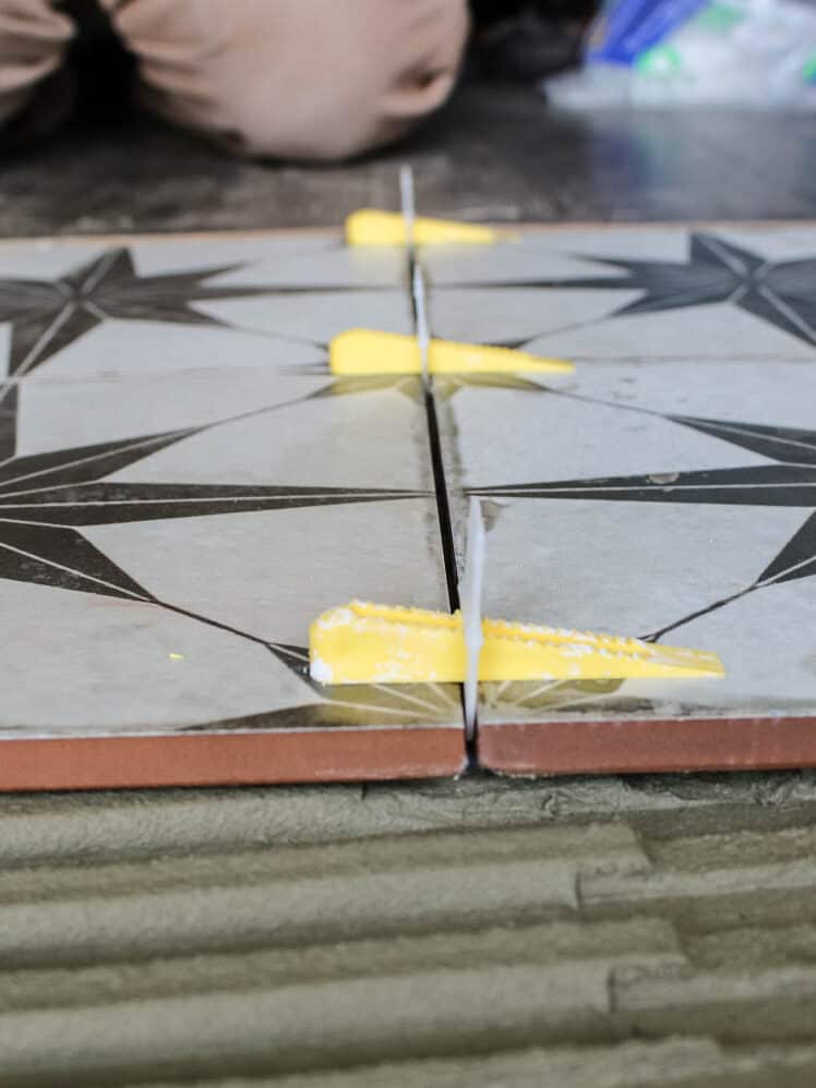 Floor tiles attached with spacers and clips on top of the floor with mortar