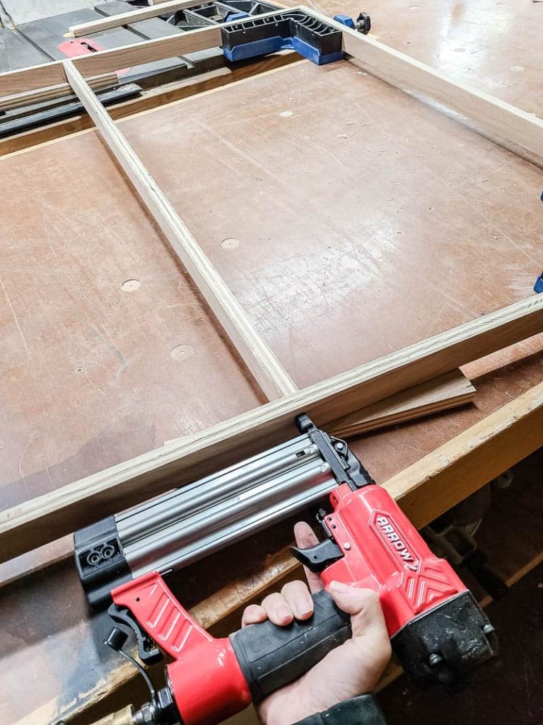 Assembling wood frame for tapestry using nail gun attaching the edges