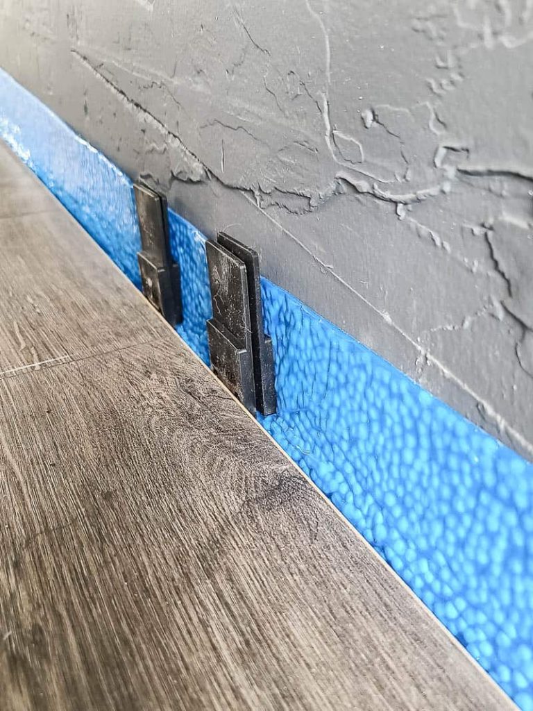 Laminate floor attached with spacer between wall for expansion gap