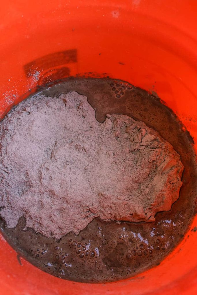 Mixed thinset and water inside the orange bucket before getting mixed up