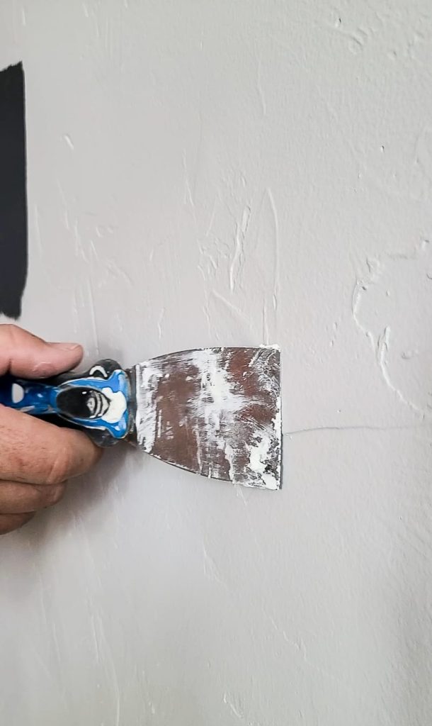 Flattening the spackle using a putty knife
