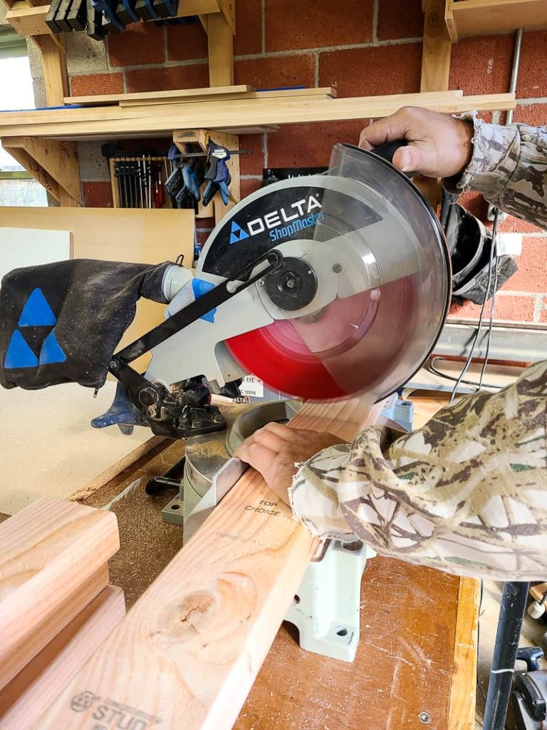 Cutting 2x4s for DIY bench using a miter saw.