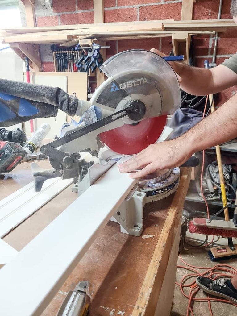 Start by cutting down trim pieces to go around the perimeter of the scuttle access hole with a miter saw
