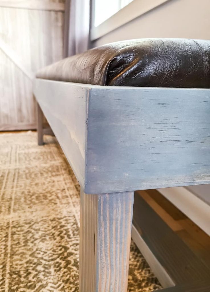 Close up of corner of finished bench with leather upholstered cushion.